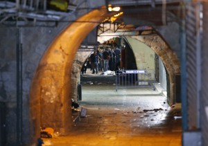 Israeli security forces and emergency services stand next to the body of a Palestinian who carried out a stabbing attack in the old city of Jerusalem on October 3, 2015. A Palestinian with a gun and a knife killed two people and wounded two others, including a child, before being killed himself by police in Jerusalem's Old City Saturday, with tensions high after recent violence. AFP PHOTO / AHMAD GHARABLI